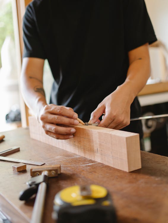 Woodworking craftsman measuring wooden plank